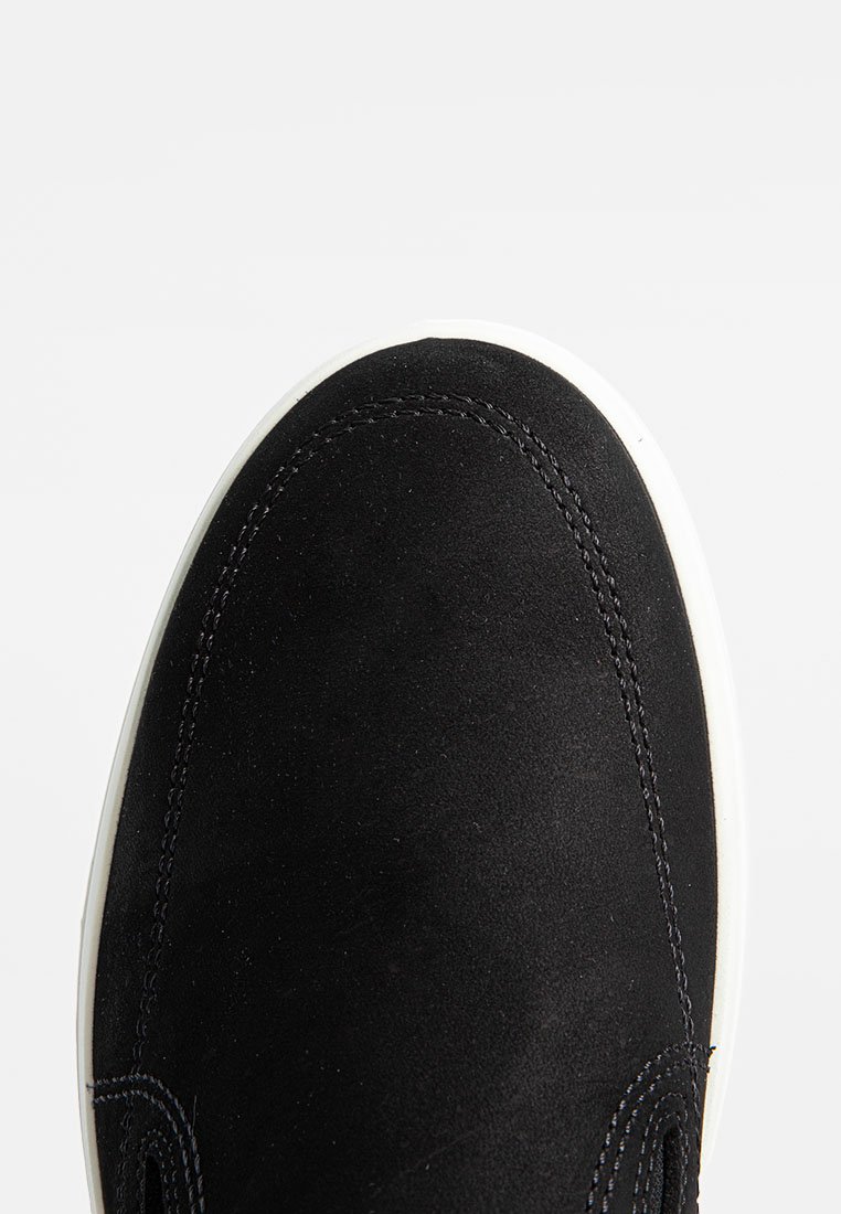 Schwarze Wildledersneaker mit runder Zehenpartie, kontrastierender weißer Gummisohle und dezentem Stichdetail entlang der Kanten. Glatte Textur.