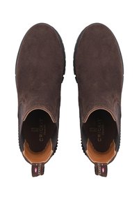 Bottines en suède marron avec des panneaux élastiques sur les côtés, des semelles en caoutchouc et une languette avec un détail coloré contrastant à l'arrière.