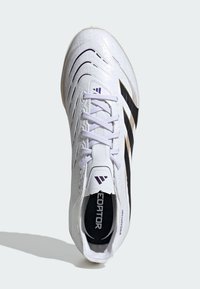 Bílá fotbalová kopačka s texturovaným svrškem, s černými a fialovými akcenty, šněrováním a zakřivenou podrážkou pro lepší výkon.