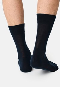 Calcetines azul marino con una textura suave, puño acanalado y talones reforzados. Diseñados para comodidad y ajuste, adecuados para uso casual.