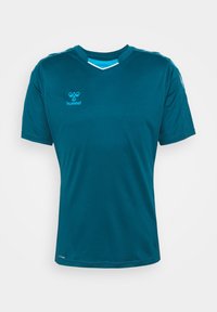 Maillot de sport bleu sarcelle à manches courtes avec col en V, détails bleu clair à l’intérieur du col et petit logo hummel sur le côté gauche de la poitrine.