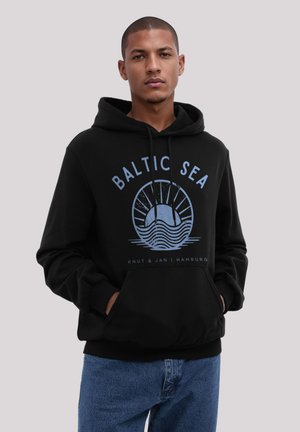 Schwarzer Kapuzenpullover mit einem blauen Grafikdesign der Ostsee, das Wellen und Strahlen zeigt. Vordertaschen und gerippte Bündchen runden das Design ab.