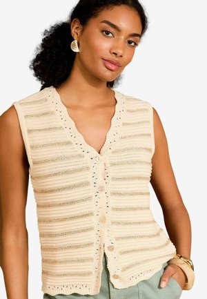 Gebreide mouwloze cardigan in lichtbeige met horizontale strepen en gekartelde randen. Voorzien van een V-hals en knoopsluiting.
