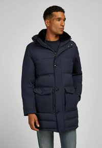 Marineblauwe pufferjas met een rits en knoopsluiting, twee voorzakken en een bontvoering aan de capuchon. Beschikt over een gestikte ontwerp en een gladde textuur.