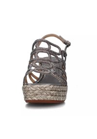 Sandalo wedge argentato in metallo con un intricato design a ritaglio, piattaforma in juta intrecciata e cinturino alla caviglia regolabile. Fodera interna liscia.