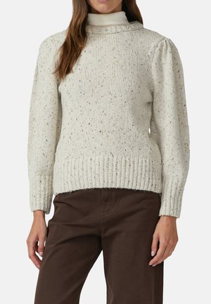 Lichtbeige gebreide trui met een hoge hals, geribbelde manchetten en zoom, met kleurvlekken door de stof voor extra textuur.