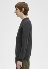 Maglione grigio scuro a maniche lunghe realizzato in tessuto morbido, con collo a giro e polsini e fondo a coste. Semplice logo ricamato sul petto.