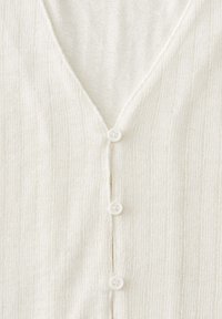 Knit cardigan in off-white with a V-neck, featuring four white buttons and a textured ribbed fabric.