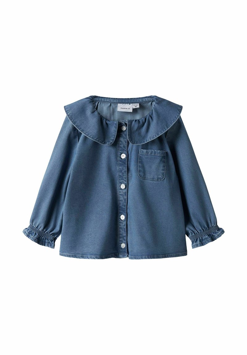 Jeansskjorta med en stor, volangprydd krage, långa ärmar med elastiska muddar, knapplist och en bröstficka; medelblå färg.