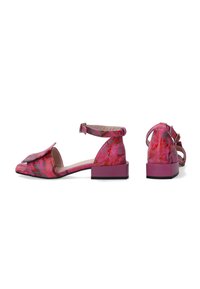 Rosa Ballerinas mit quadratischer Zehenpartie, strukturierten Oberflächen, verstellbarem Knöchelriemen und kleinem Blockabsatz. Mit einer dekorativen Klappe an der Vorderseite.