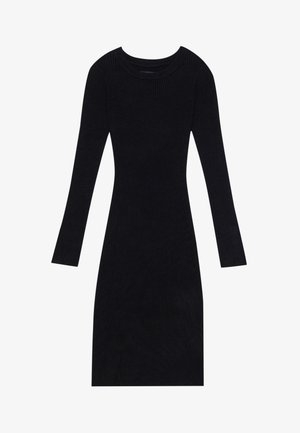 Abito nero a coste con maniche lunghe, scollatura rotonda e silhouette aderente. Tessuto testurizzato che arriva fino al ginocchio.