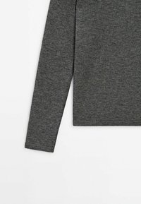 Manche et côté d'un pull en maille gris foncé à manches longues, présentés sur fond blanc, avec un design simple, ajusté et sans coutures.