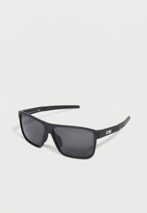 Lunettes de sport rectangulaires noires avec verres foncés et logo Bliz sur les branches, sur un fond clair uni.