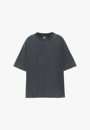 T-shirt gris foncé surdimensionné à manches courtes avec col rond et petit logo brodé sur le côté gauche de la poitrine.