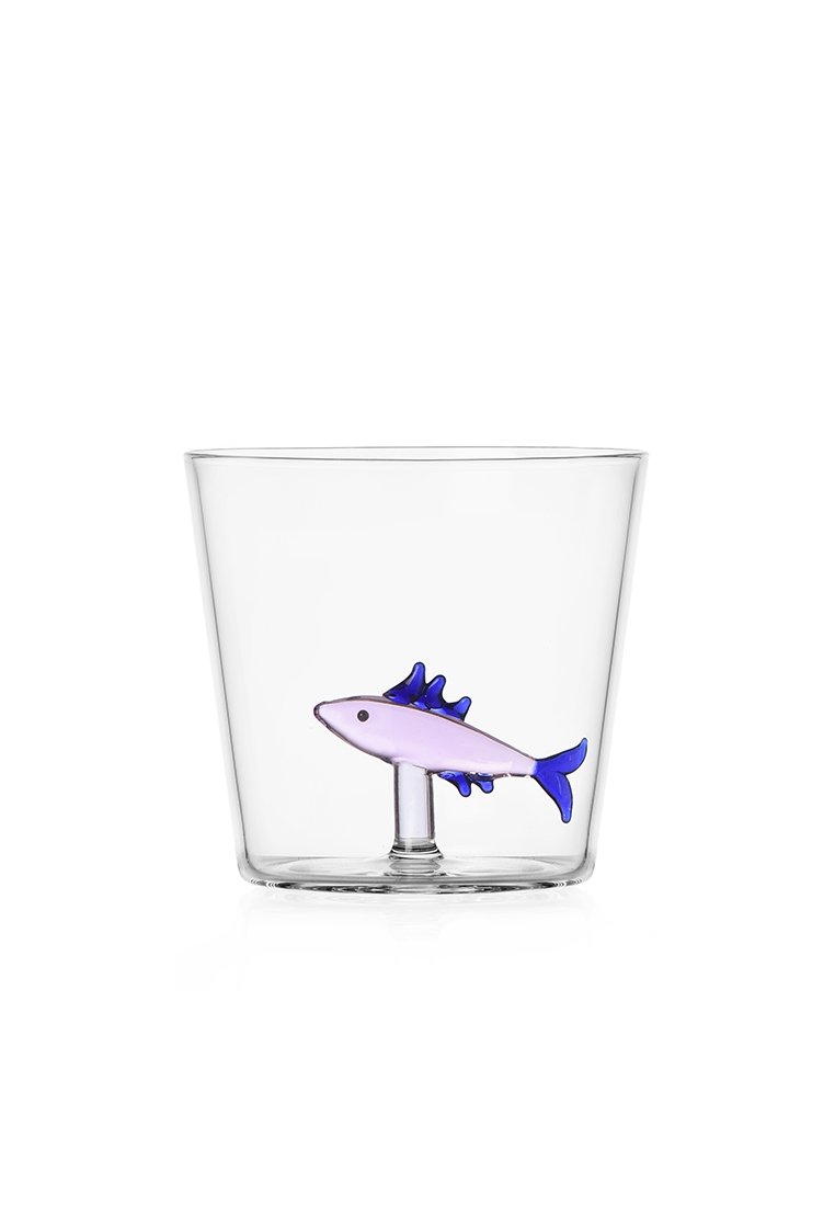 Przezroczysta szklana miska z małą, kolorową figurką w kształcie ryby w fiolecie i niebieskim na dnie. Gładka tekstura z prostym wzorem.