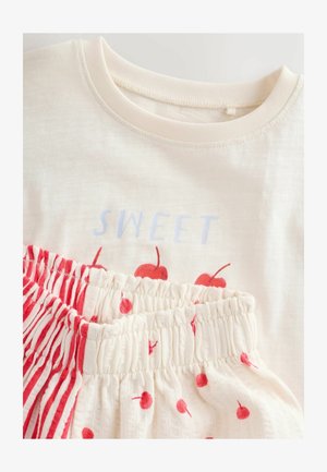 Katoenen shirt in crème met "SWEET" in lichtblauw en rode kersenprint; bijpassende shorts met rode strepen en polka dots. Zachte, gestructureerde stof.
