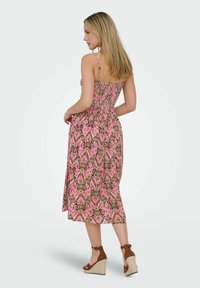 Rosa och brun mönstrad klänning med figursydd överdel och smockad rygg, som har tunna axelband och en flödande, midilängd silhuett.