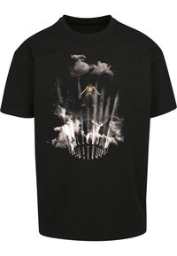 Svart bomull T-skjorte med et grafisk motiv av en figur som hopper omgitt av skyer og lysstråler, noe som skaper en dynamisk visuell effekt.