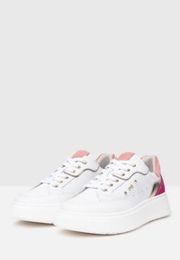 Baskets en cuir blanc avec des accents en daim rose, œillets dorés et une épaisse semelle blanche. Comprend des perforations sur le côté et une finition lisse.