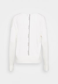 Bílý pletený svetr s kulatým výstřihem, žebrovanými detaily na ramenou a centrálním logem v černé barvě podél zadního švu.