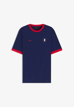 Granatowy t-shirt z krótkim rękawem z czerwoną lamówką na kołnierzyku i mankietach, czerwonym logo "BOSS" na piersi oraz emblematem w kształcie tarczy z czerwonymi, białymi i niebieskimi paskami.