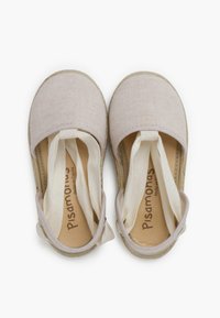 Zapatos de lona beige con correas elásticas, puntera redonda y suela de goma natural. La etiqueta interior dice "Pisamonas, Hecho en España."