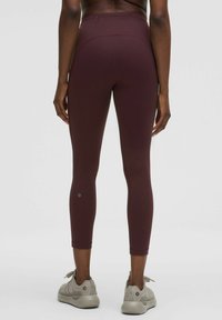 Bordó leggings rugalmas anyagból, testhezálló dizájn, középidőig érő hossz, diszkrét logóval az alsó lábszáron és magas derékkal.