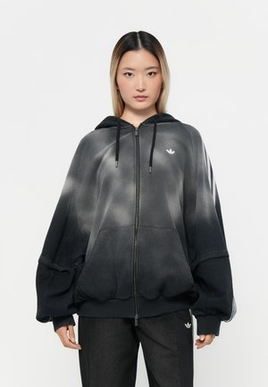 Felpa con zip in gradiente nero e grigio, con cappuccio regolabile, design oversize e un piccolo logo bianco sul petto. Polsini e orlo a coste.