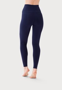 Granatowe legginsy z wysokim stanem, wykonane z elastycznej tkaniny, charakteryzujące się gładką teksturą i dopasowanym krojem, kończące się przy kostce.