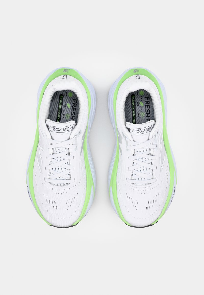 Baskets de course blanches avec des accents verts, tige en maille respirante, semelles amortissées et détails perforés pour la ventilation. Présente un branding visible.