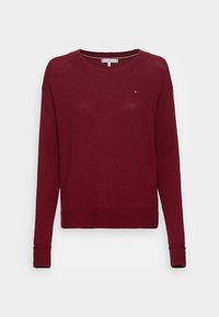 Pull tricot marron à manches longues avec poignets et ourlet côtelés, encolure ronde et petit logo Tommy Hilfiger sur la poitrine.