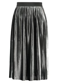 Falda plisada metálica con rayas verticales alternadas en negro y plata, con una amplia cintura elástica negra y una textura fluida.