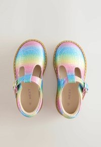 Colorful, iridescent Mary Jane shoes with a textured finish, featuring a buckle strap and cut-out design. Sole is tan with stitch detailing.