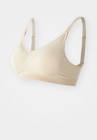 Beige sømløs trådløs BH med justerbare stropper og ribbete underbånd, designet for komfort og lett støtte.