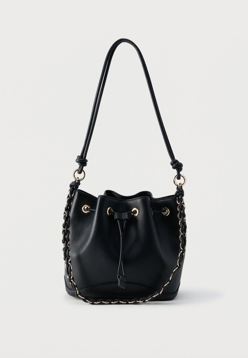 Μαύρη δερμάτινη τσάντα τύπου κάδος με κλείσιμο με κορδόνι, χρυσά μεταλλικά δακτυλίδια, μακριά ιμάντα ώμου και λαβή με αλυσίδα σε απλό φόντο.