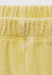 Geel badstof met een gestructureerd oppervlak en een gerimpelde tailleband. Kenmerkt zich door zacht, absorberend materiaal en een verticale ribbelpatroon.