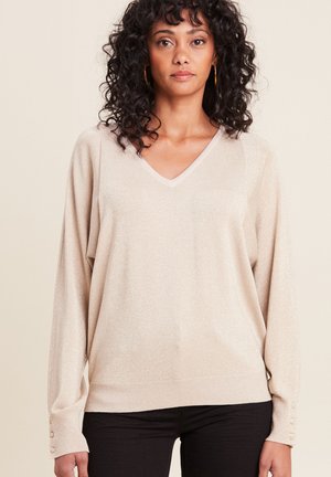 Helles beige V-Ausschnitt Pullover mit weicher Textur, langen Ärmeln und Knopfakzenten an den Manschetten. Glitzernde Fasern sorgen für einen subtilen Schimmer.