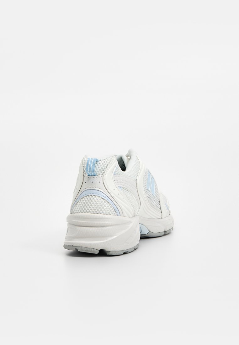 Scarpe da ginnastica bianche in mesh con dettagli azzurri, colletto imbottito e suola ammortizzata con una presa testurizzata. Vista posteriore.