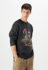 Black sweatshirt with crew neck, featuring colorful graphic print of animals and train. Made from cotton blend with ribbed cuffs and hem.
