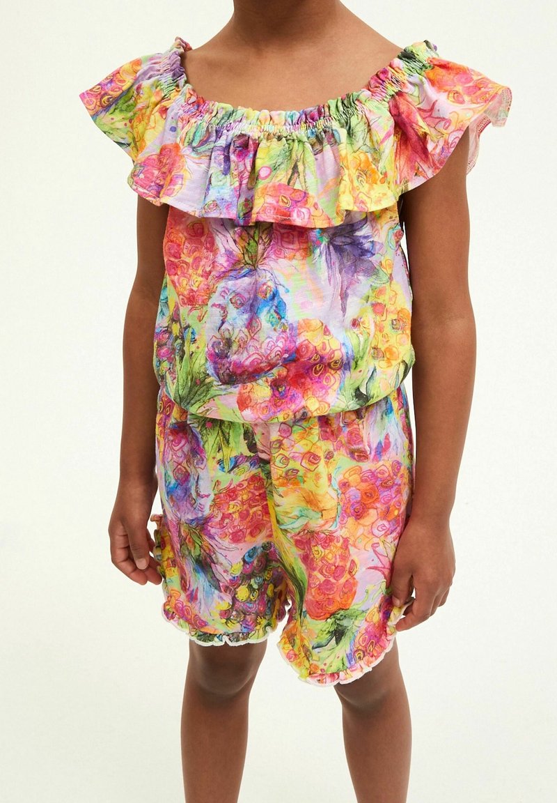 Tenue colorée à motifs floraux avec un col à volants, des manches courtes et un short assorti aux bords volantés. Le matériau semble léger et texturé.