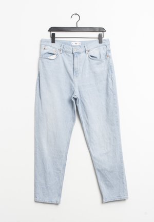Lyseblå højtaljede jeans med for- og baglommer, bæltestropper og knaplukning hængende på en sort bøjle.