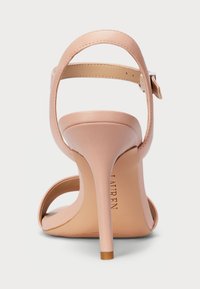 Rausvos odinės aukštakulnių šlepečių su plonu stiletu, reguliuojama kulkšnies juosta ir atvira noselė. Lygi tekstūra, minimalistinis stilius.