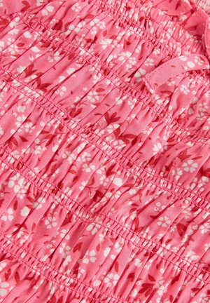 Tissu de robe florale rose avec une texture froncée, présentant des motifs floraux blancs et plus foncés. Matière douce avec des sections élastiques pour un ajustement optimal.