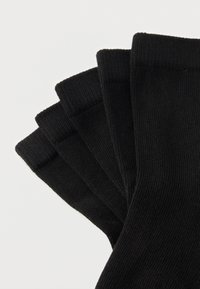 Μαύρες βαμβακερές κάλτσες σε διάταξη σαν αέρας. Διαθέτουν ριγωτή υφή και ελαστικές μανσέτες. Μαλακό υλικό και αδιάκοπος σχεδιασμός.