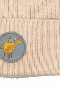 Ribbattu beige-neulepipo, jossa on pyöreä harmaa päällinen, jossa on keltainen lehmä- ja lintu- grafiikka. Pipo on valmistettu pehmeästä, teksturoidusta kankaasta.