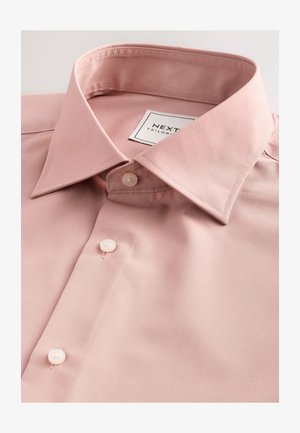 Camicia rosa chiaro con colletto classico, caratterizzata da bottoni di perla e un'etichetta con la scritta "NEXT TAILOR." Tessuto liscio e strutturato.