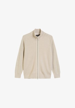 Beige ritsvest van breiwerk. Heeft een hoge kraag, lange mouwen en geribbelde manchetten. Schone uitstraling met een gladde textuur.