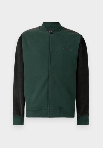 Grön sweatshirtjacka med svarta ärmar; har tryckknappsstängning, logotyp på bröstet och ribbade mudd och nederkant. Mjuk textur.