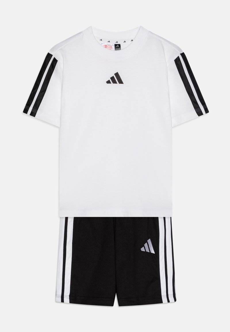 Camiseta blanca con el logo negro de Adidas en el pecho, combinada con pantalones cortos negros que tienen rayas blancas a los lados y el logo en la pierna izquierda. Material de algodón.