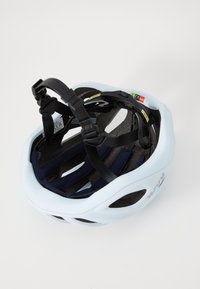 Casque de vélo bleu clair avec des sangles et un rembourrage noirs, présentant des trous de ventilation et des étiquettes de certification à l'intérieur.